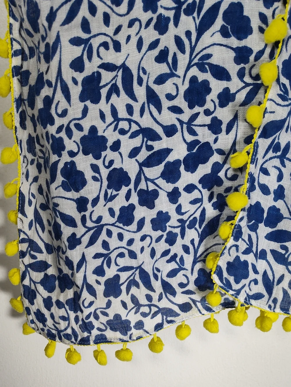 White and‎ blue floral pattern scarf with bright yellow pom pom trim